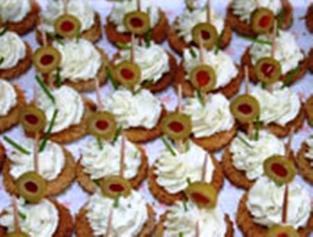 Tapa de masa con crema de alcaparras y cierre de aceituna rellena.